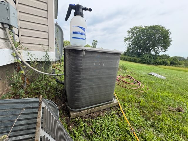 Same outdoor AC condenser with the cage removed and coils exposed after debris was cleared